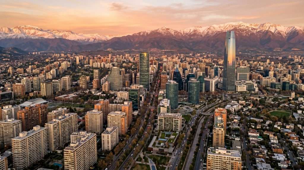 Vista aérea de Santiago de Chile con torres residenciales y la cordillera de los Andes al atardecer
